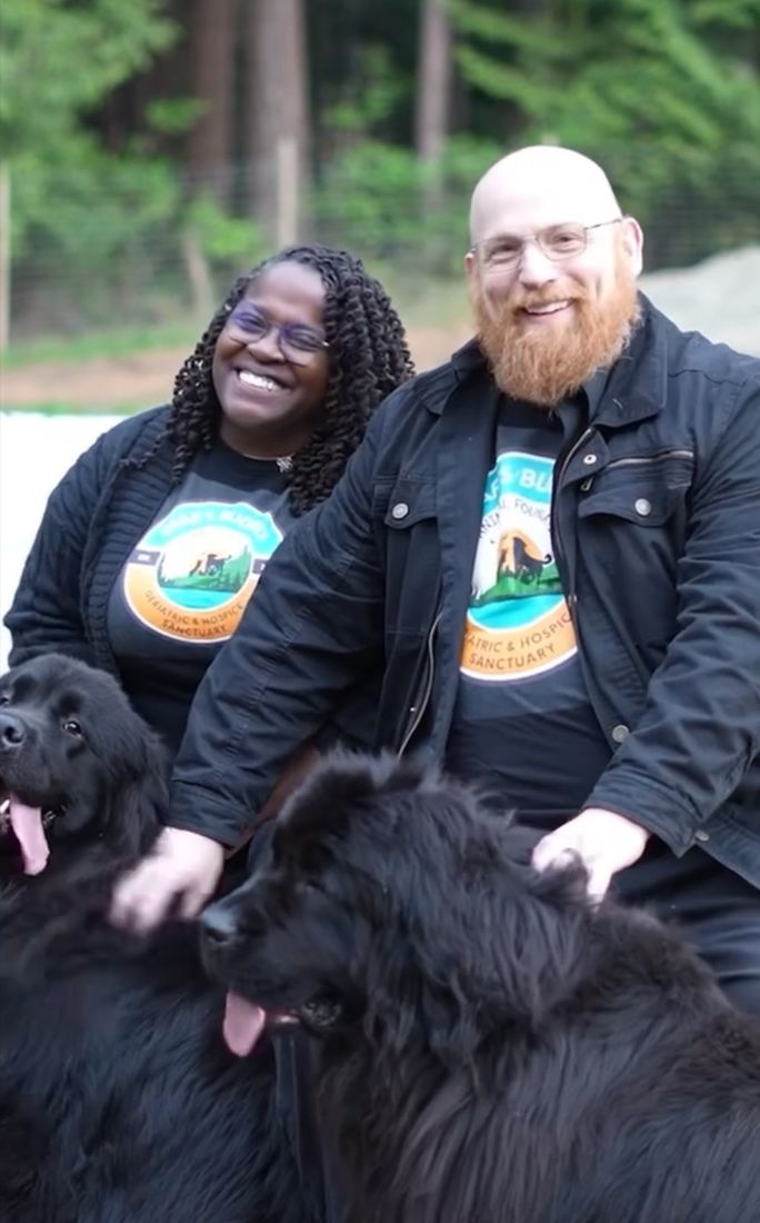 Kimberly and Keith Spinks outdoors with their two Newfoundland dogs, Laverne and Shirley